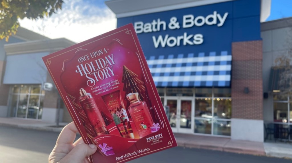 hand holding packet in front of bath and body works storefront