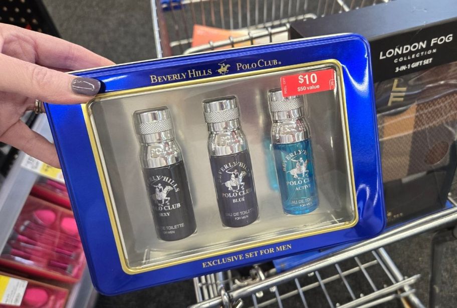 a womans hand holding a gift set of mens cologne