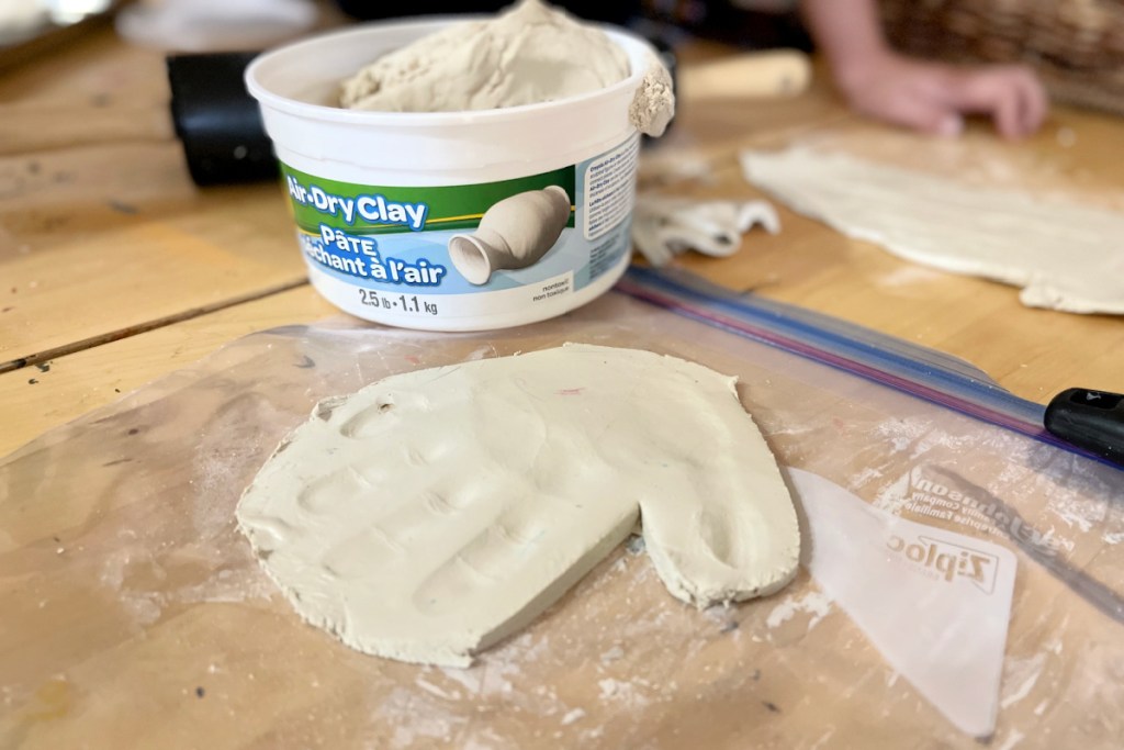 cutting away access dough to make handprint ornaments