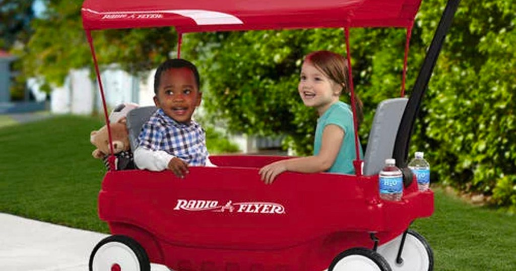 two kids sitting in red radio flyer wagon