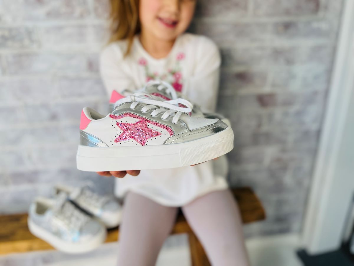 girl holding sneakers