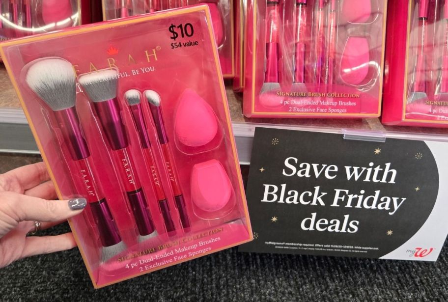 a womans hand holding a makeup brush gift set