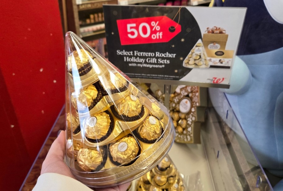 a womans hand holding a gift cone of chocolates