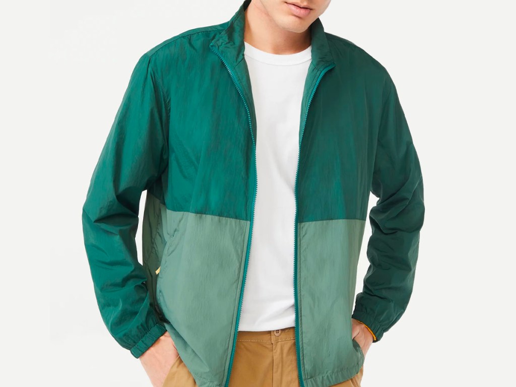 man wearing green colorblock jacket and white tee