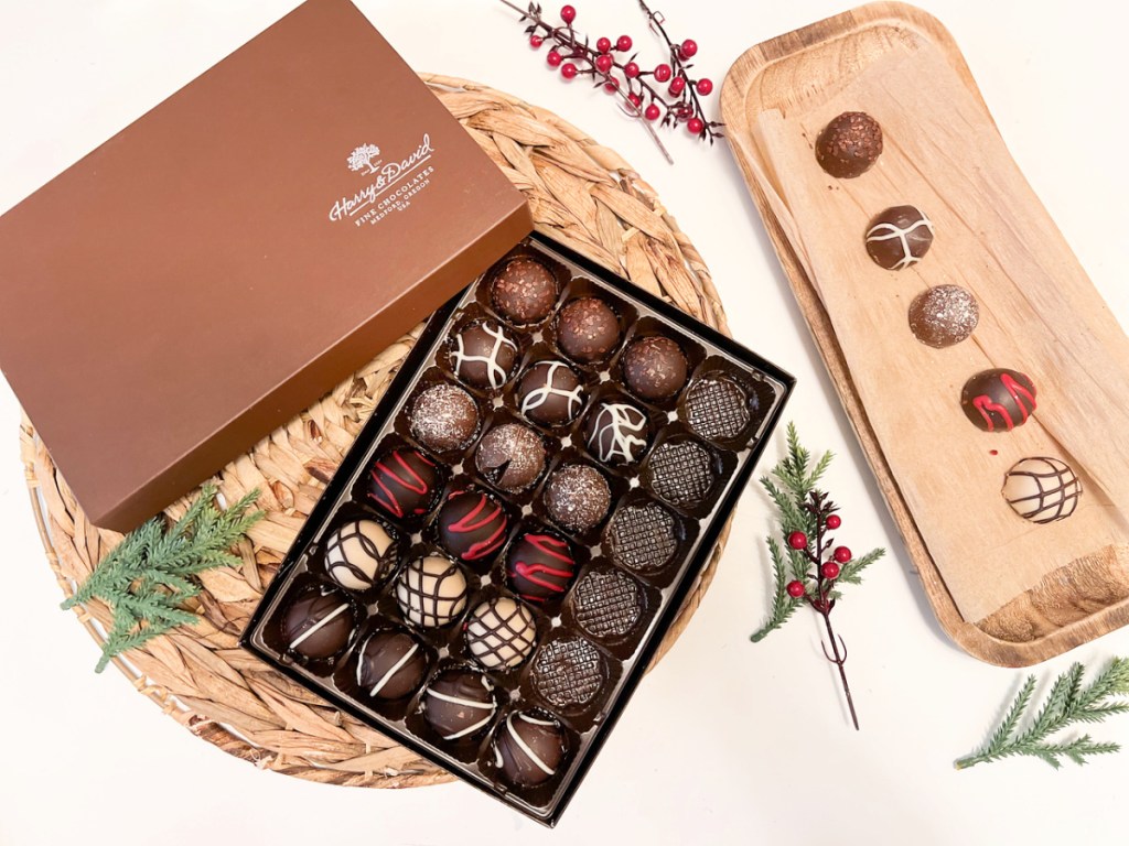 harry & david chocolate truffles in box and on a tray surrounded by Christmas greenery
