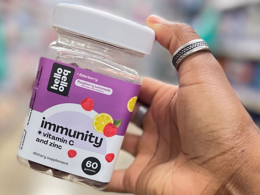 Hand holding up a jar of Hello Bello Immunity Gummies