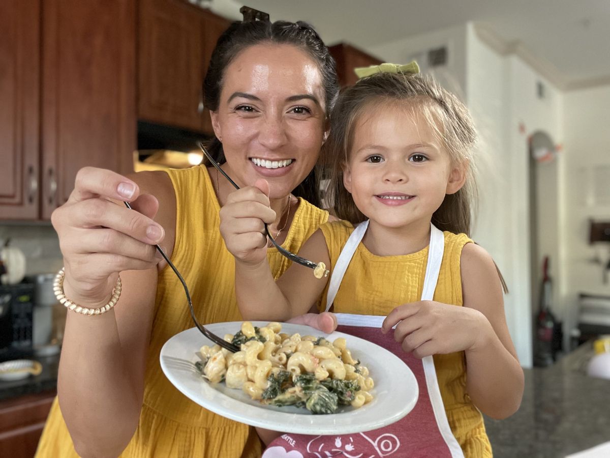 woman and daughter holding up plate of food