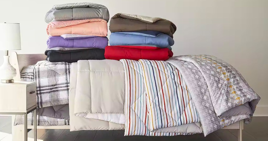 comforters in multiple colors folded and stacked on bed