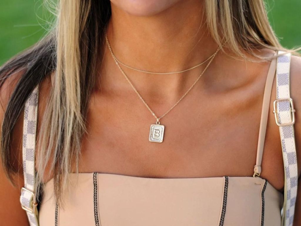 woman wearing square stamped initial necklace
