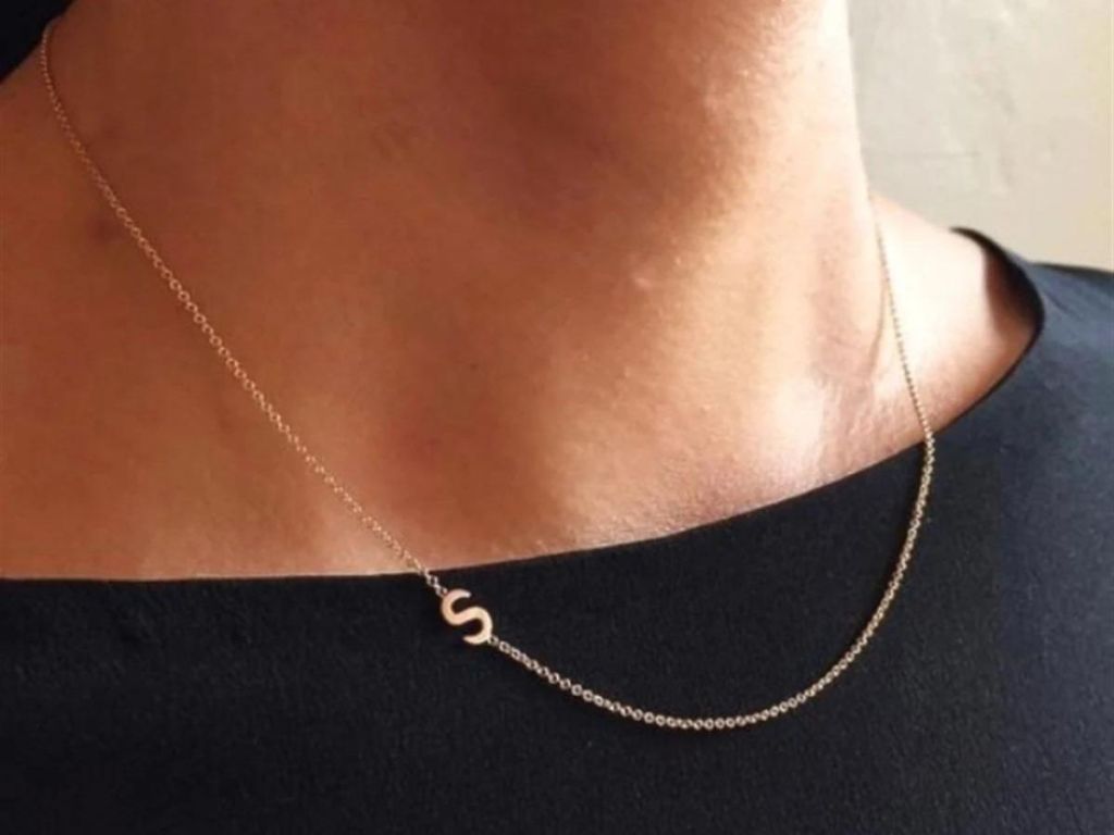 woman wearing sideways initial necklace