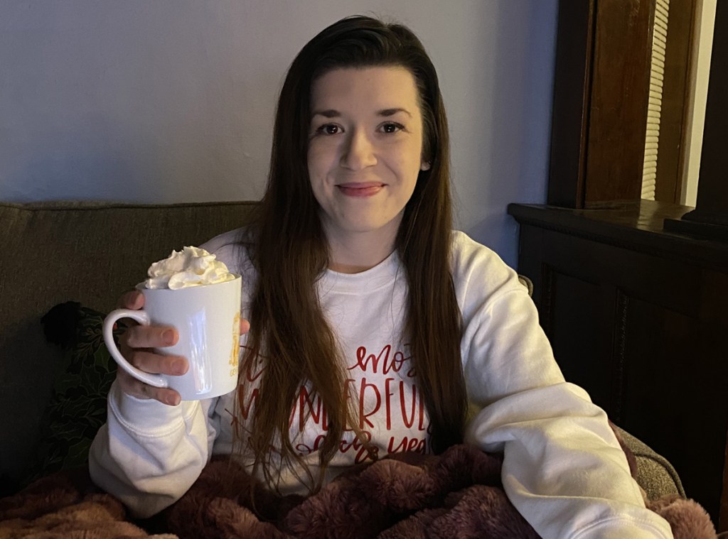 woman wearing christmas sweater with hot cocoa mug