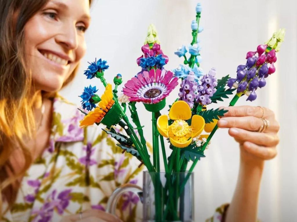 woman putting LEGO Icons Wildflower Bouquet in vase
