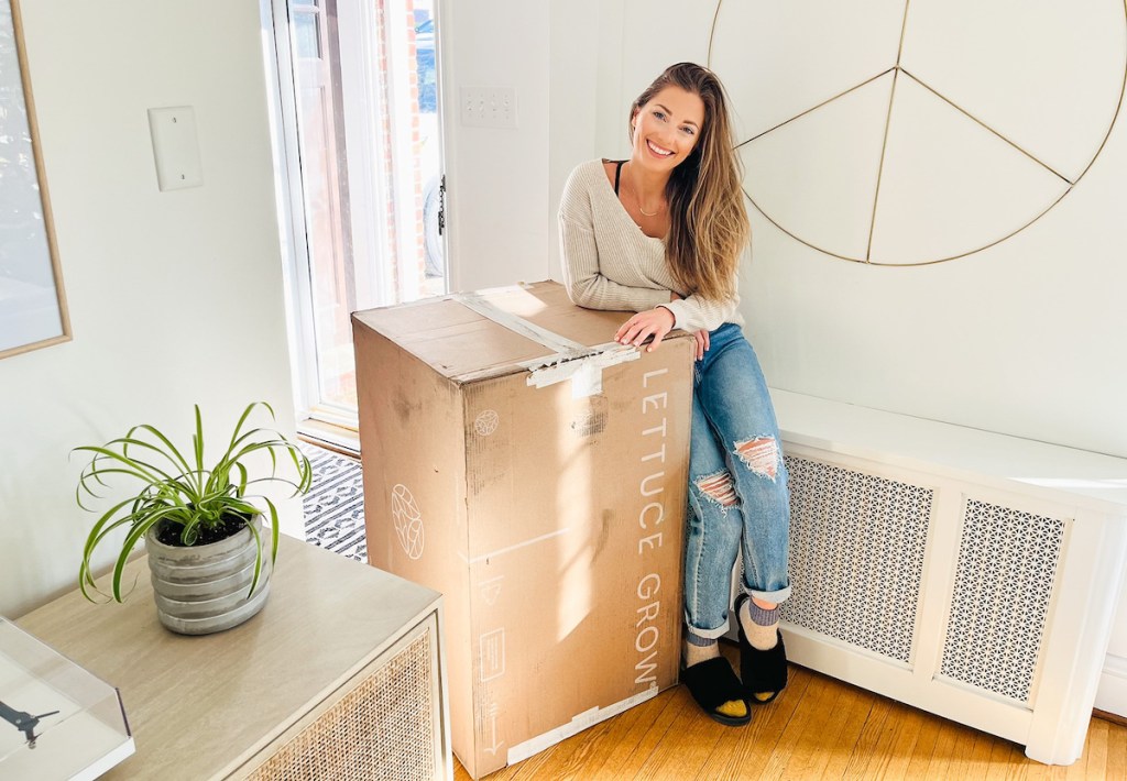 woman leaning on lettuce grow box next to radiator