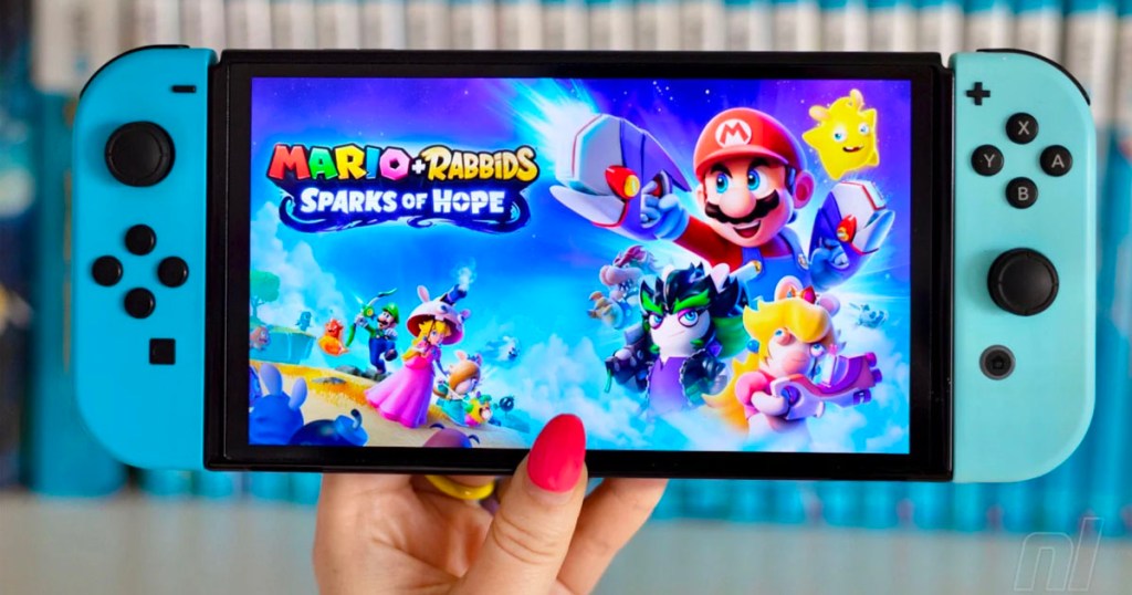 hand holding nintendo switch with mario rabbids sparks of hope game playing