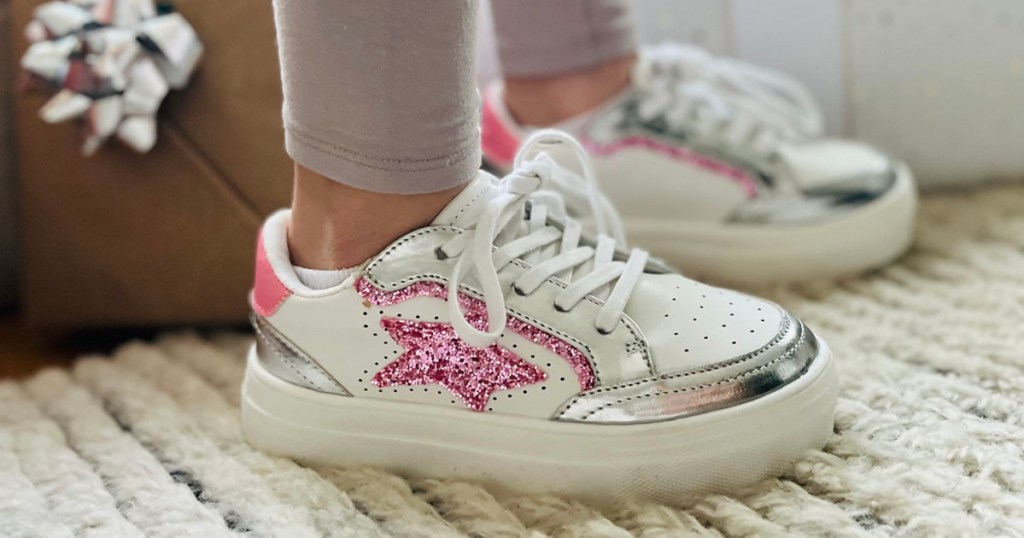girl wearing maurices pink star glitter shoes