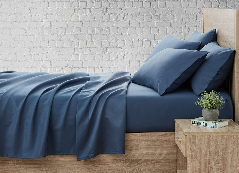 navy blue serta sheet set on a bed