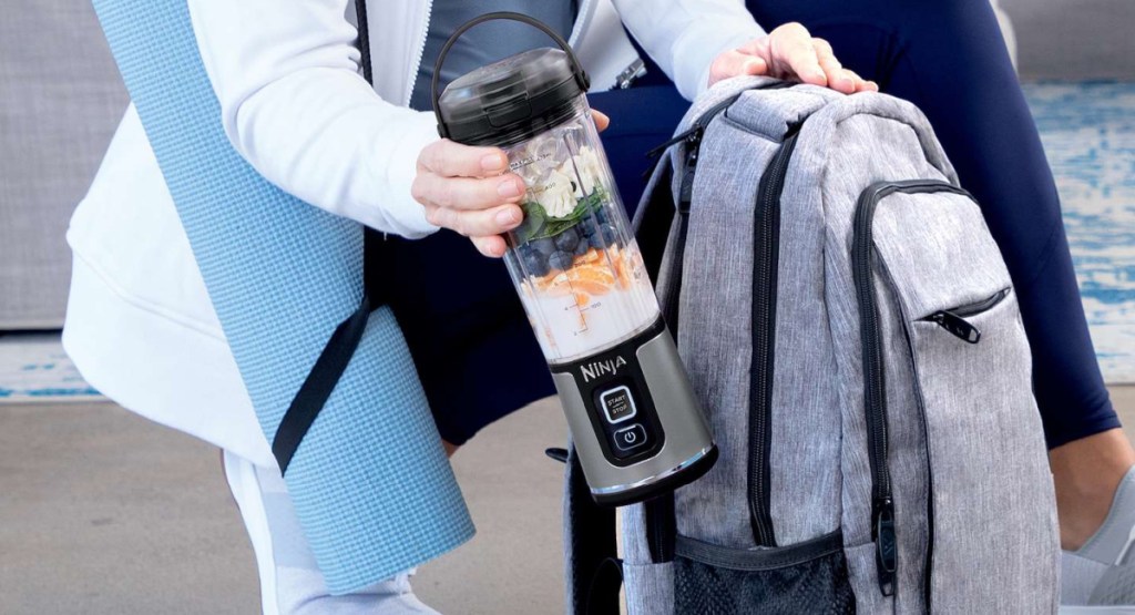 person putting the portable ninja blender in their bag