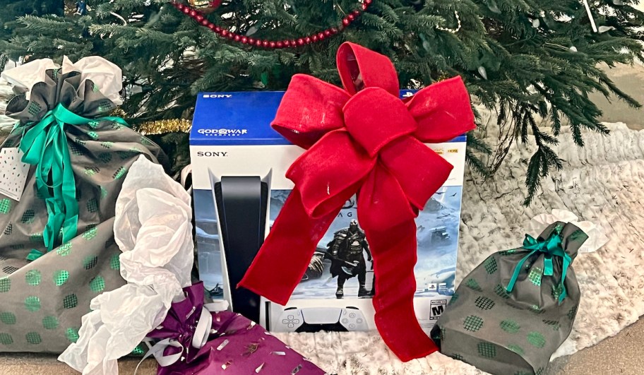 playstation 5 sitting under christmas tree with big red bow