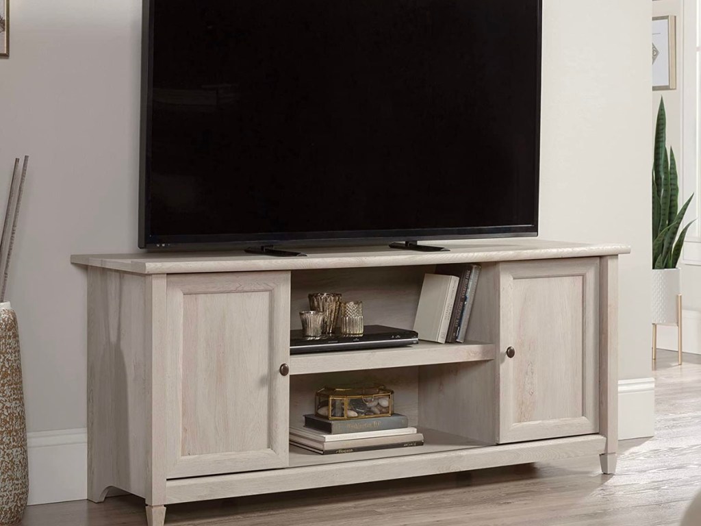 white tv stand with tv on top