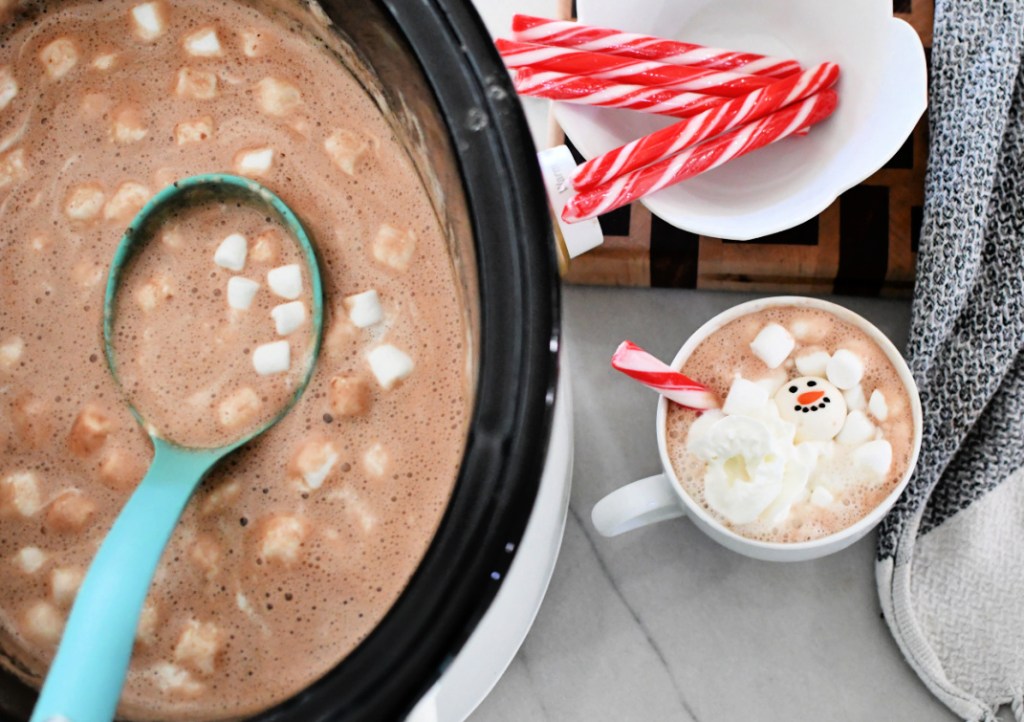 slow cooker next to a mug with hot chocolate
