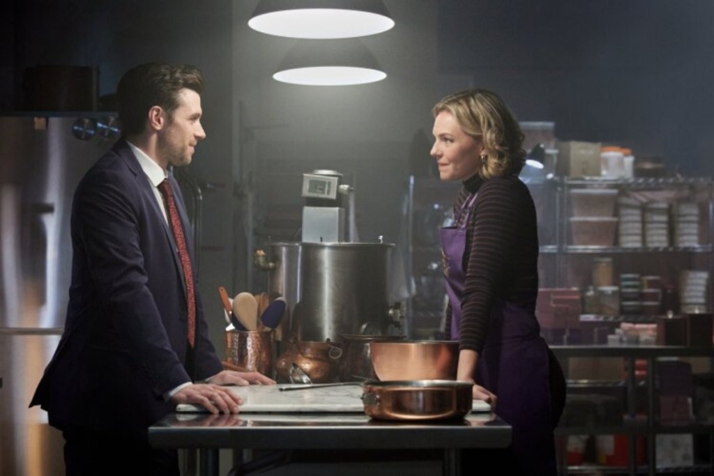 man and woman standing in dark kitchen
