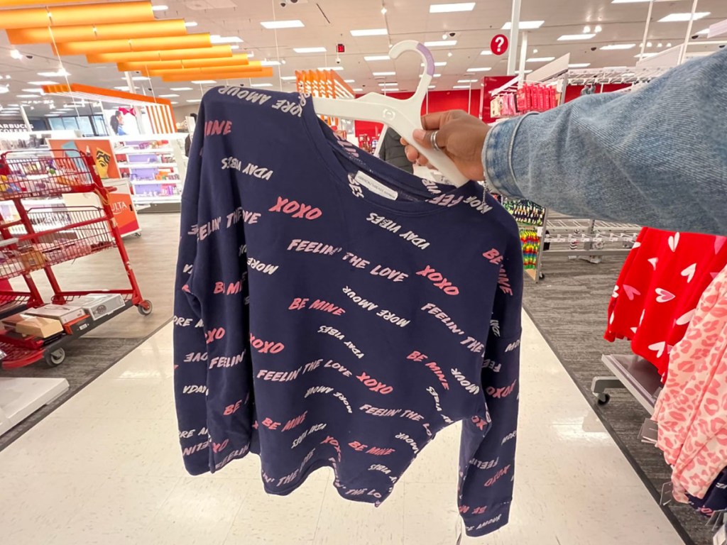 woman holding valentines pajamas in target