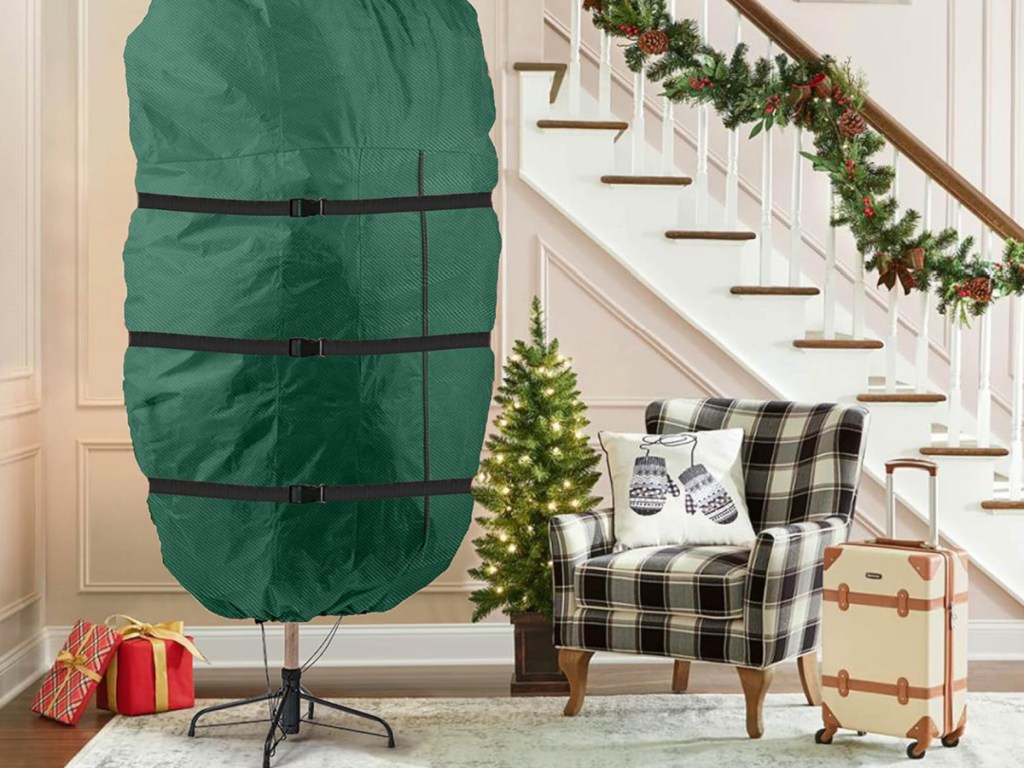 Green plastic storage bag over artificial Christmas trees, standing upright in entryway