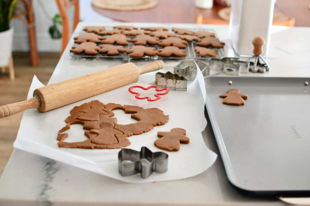 using cookie cutters to cut sugar cookie dough