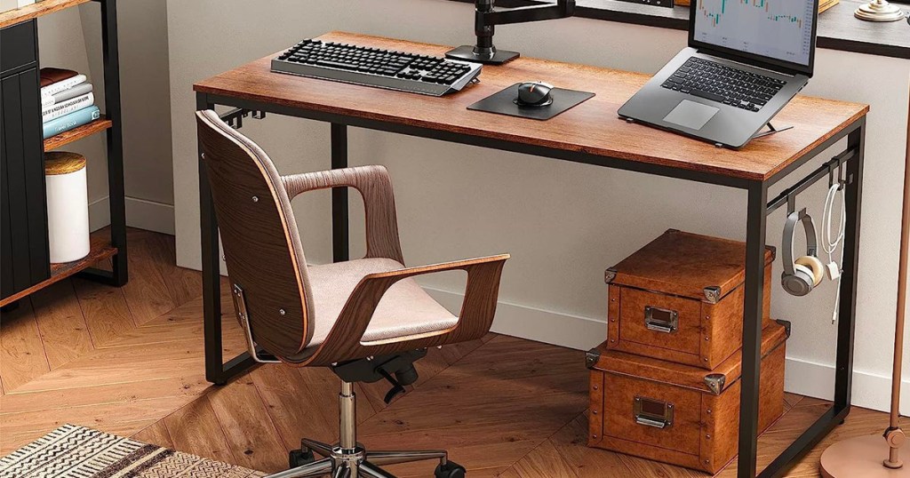 brown and black computer desk with computers are on top and chair