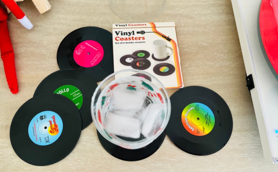 vinyl coasters on wood table with glass of ice water