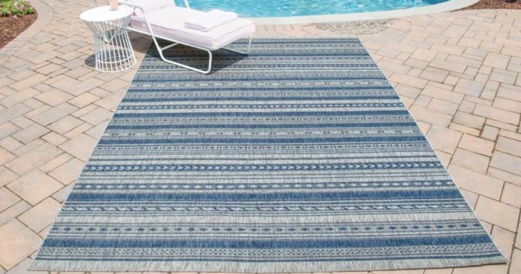 blue striped area rug on patio by pool