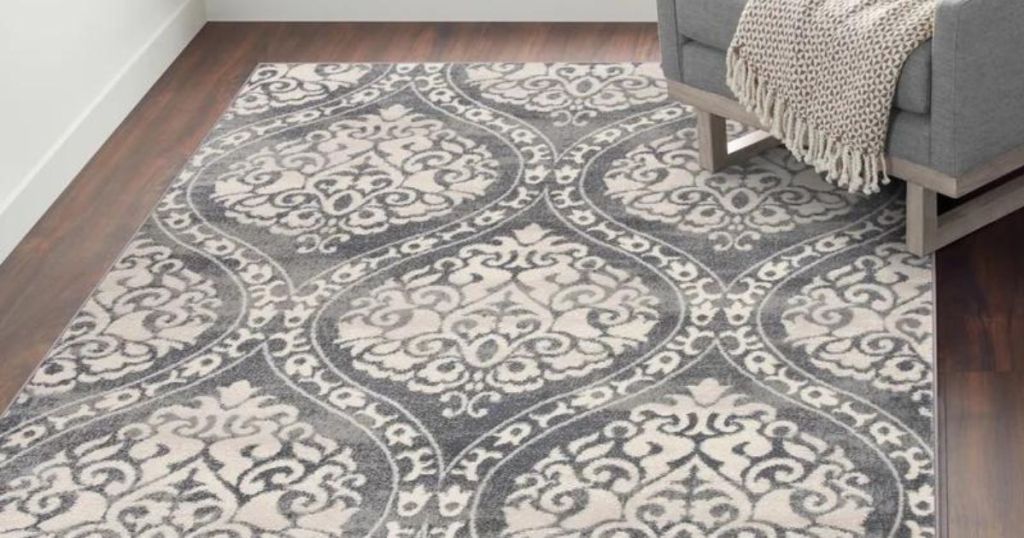 gray and white swirly area rug on hard wood floor with gray chair on it