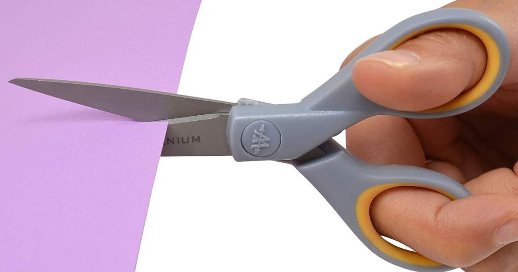 person using scissors on purple paper