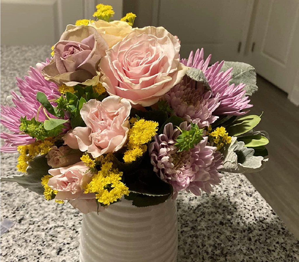 bouquet of flowers in a vase sitting on a counter