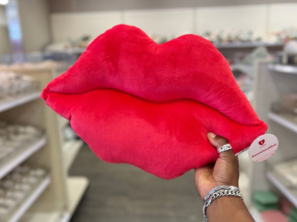 hand holding red lips pillow at Target