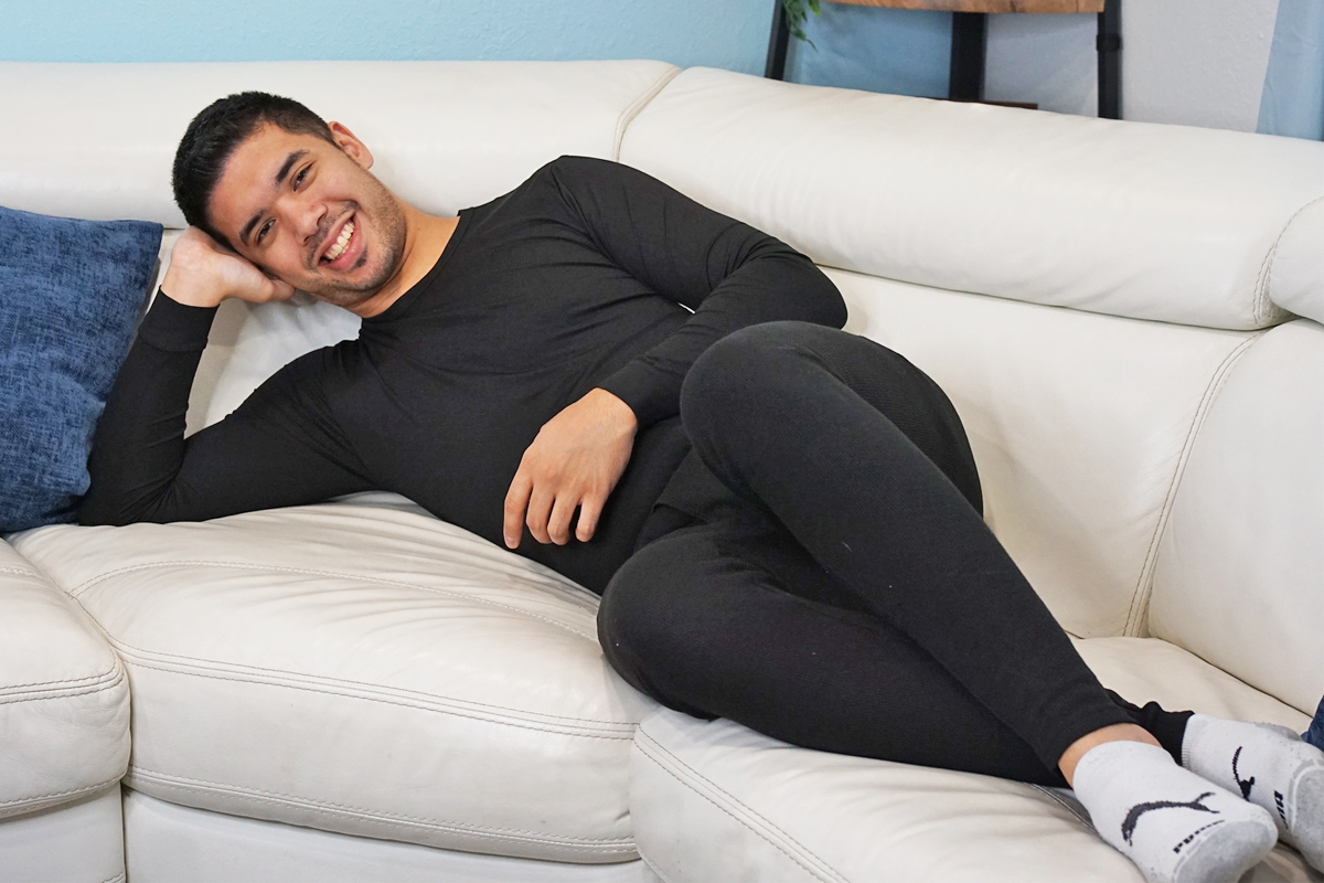 man laying on couch wearing matching black baselayers