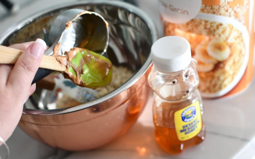 A mixing bowl and container of honey on a kitchen counter