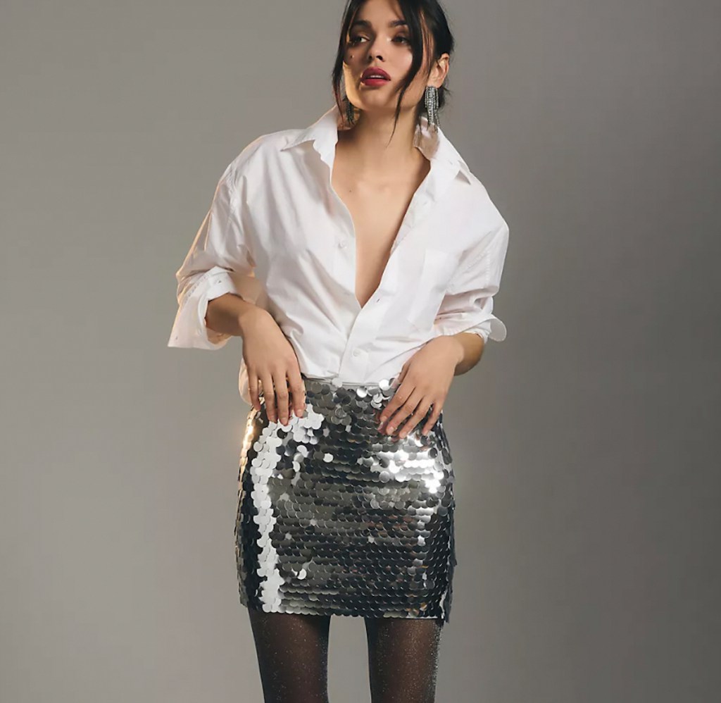 anthropologie clothes woman wearing white button down shirt with silver sequin mini skirt