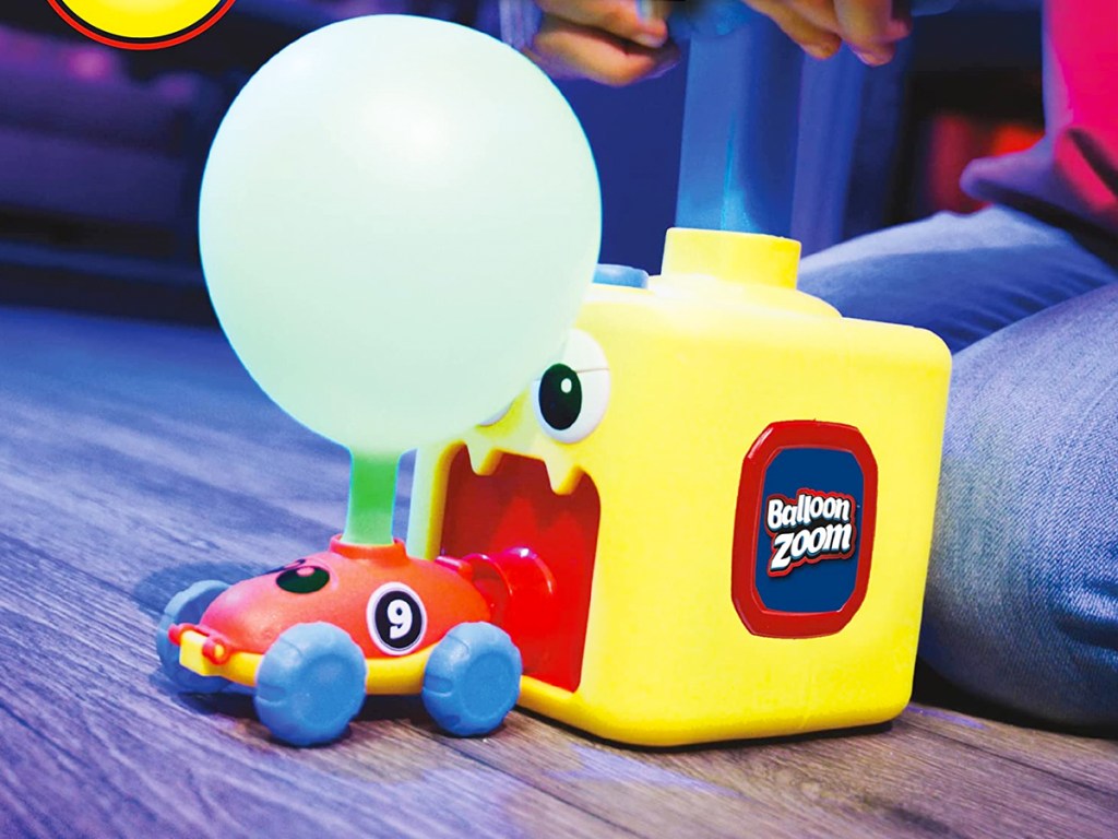 using balloon zoom to pump up balloon on top of toy car