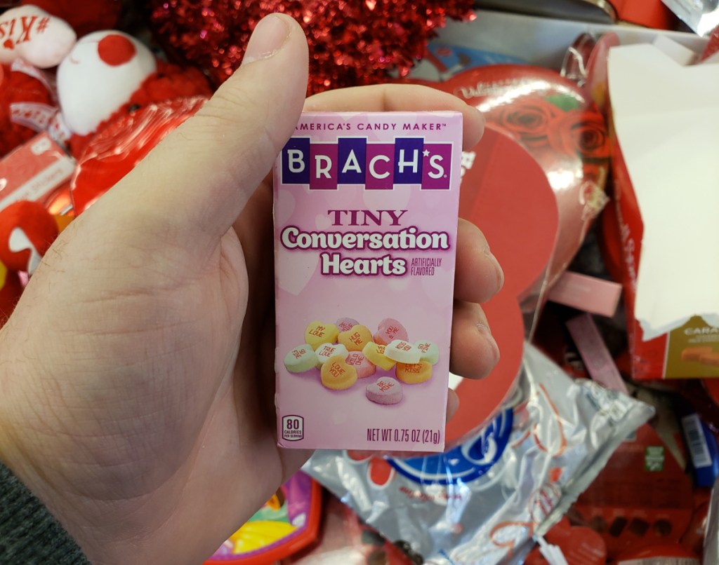 Hand holding an individual pack of Brach's Conversation Hearts