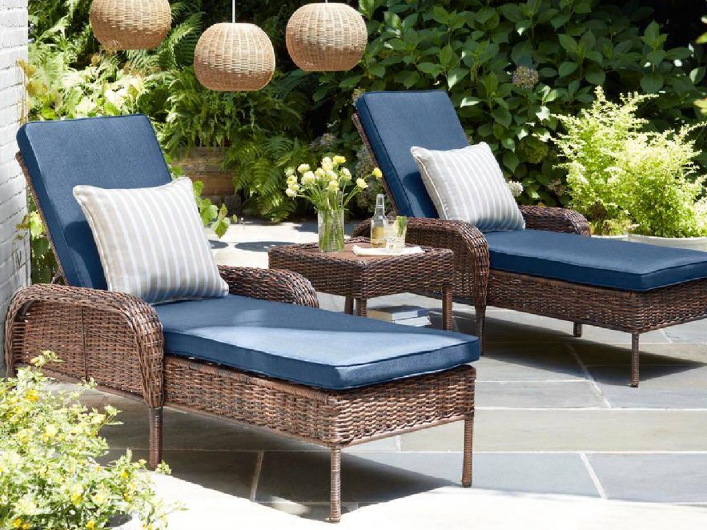 Brown Wicker Outdoor Patio Chaise Lounge w_ Cushions with light fixtures above it