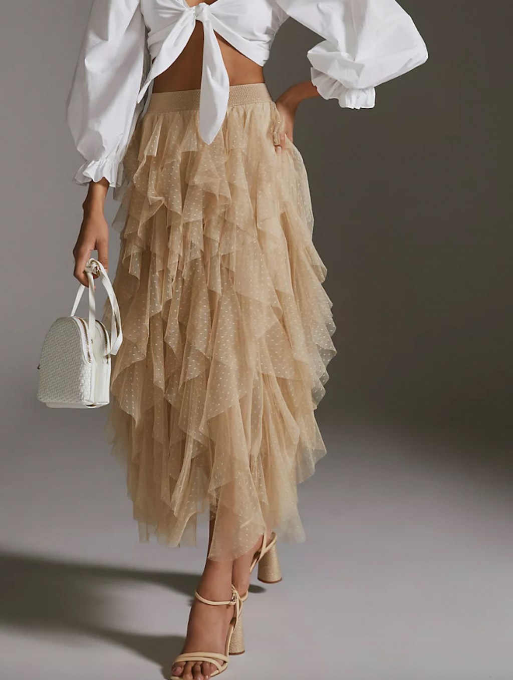 women wearing beige tulle skirt with white top and purse