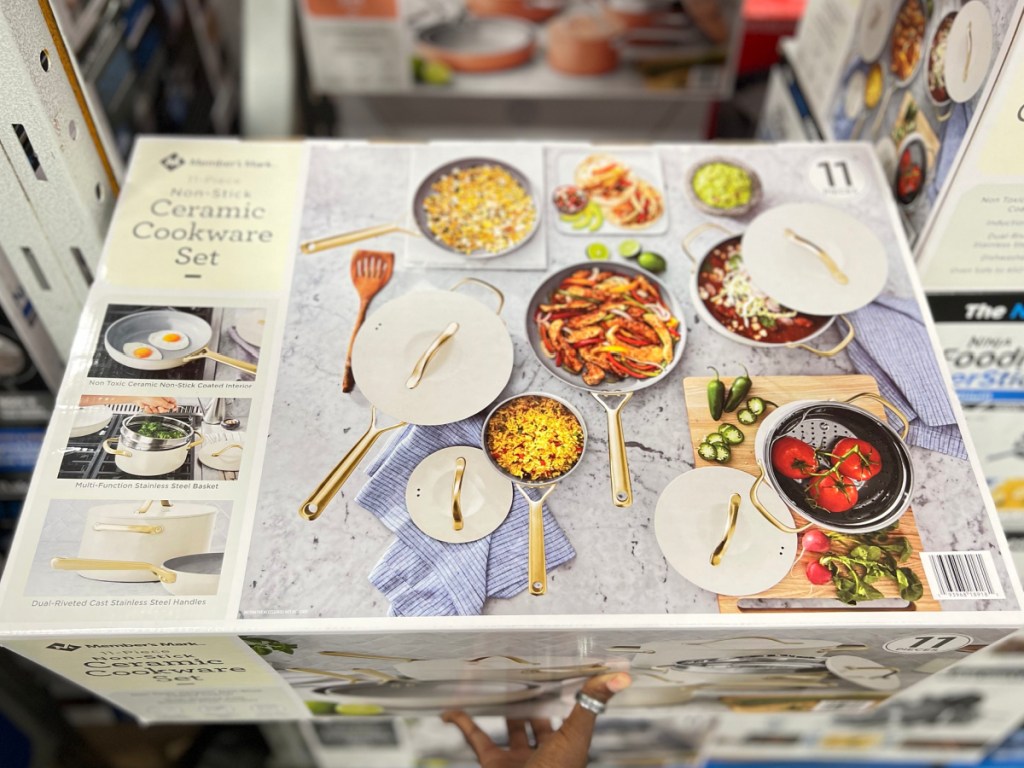 Ceramic cookware set displayed in Sam's club with woman's hand