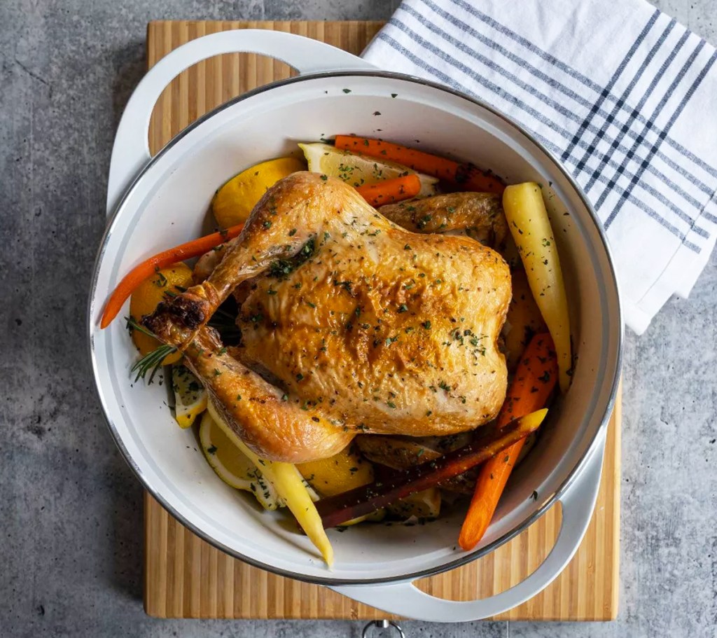 chicken and carrots inside a white dutch oven