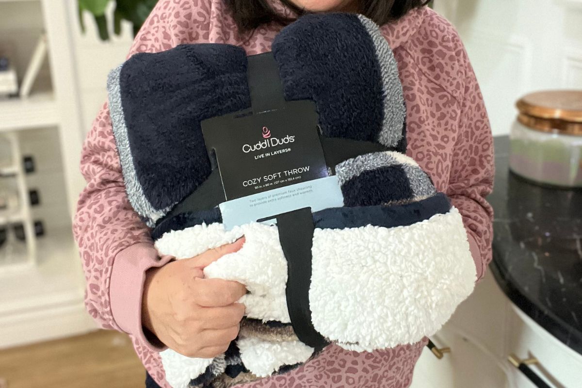 a woman holding a Cuddl Duds Sherpa Throw