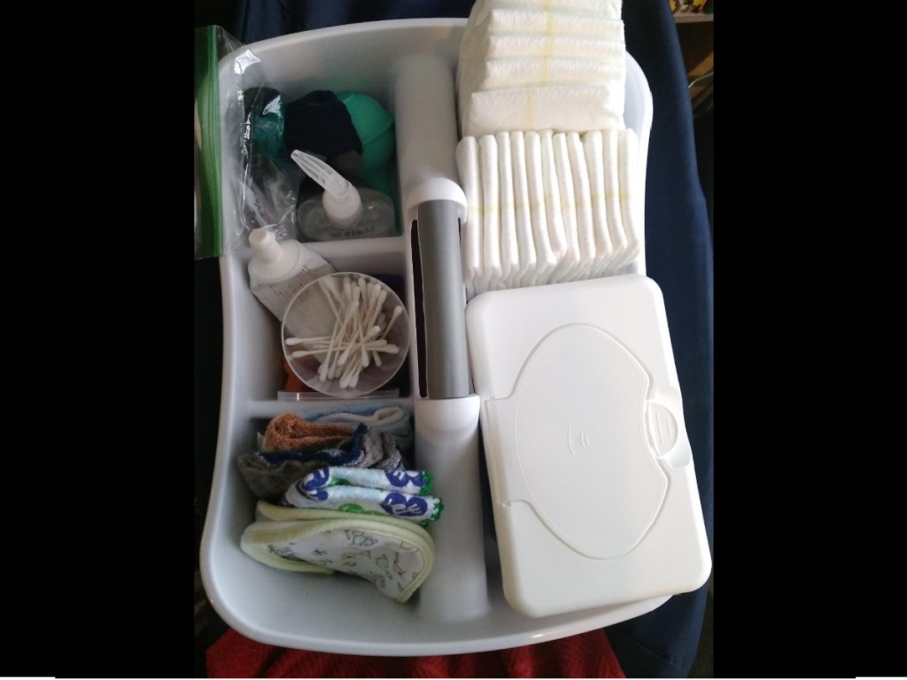 white plastic caddy being used to hold diaper changing supplies