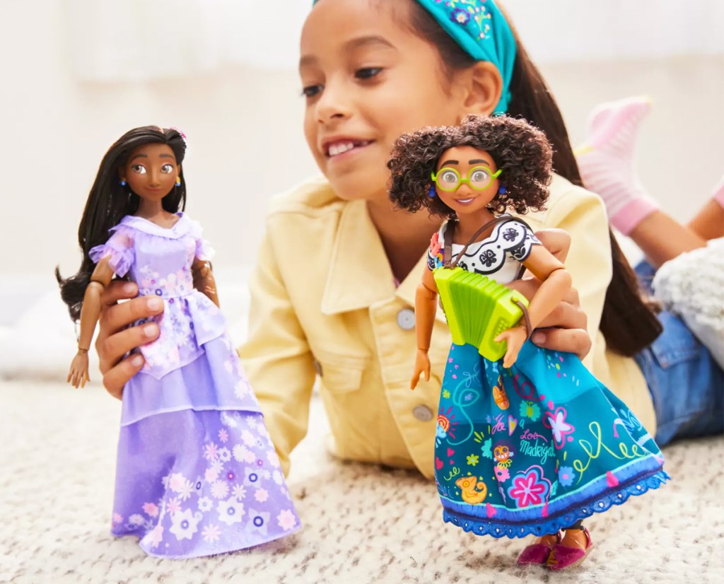 girl playing with two disney dolls