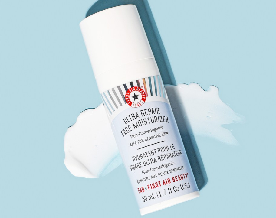 bottle of First Aid Beauty Ultra Repair Face Moisturizer on blue background