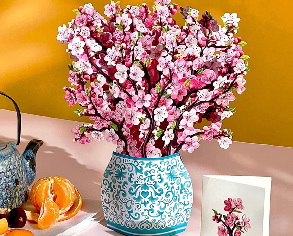 paper bouquet of cherry blossoms in blue vase with greeting card