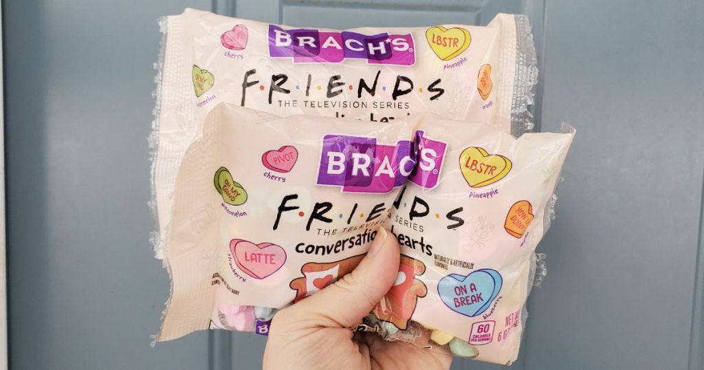 hand holding up 2 bags of Brach's Friends Conversation Hearts